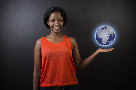 South African or African American woman teacher or student holding world earth globe in the palm of her had on black backgroundの写真素材