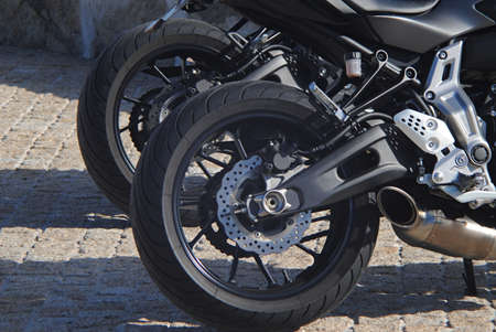 Two wheels of motorbikes - photograph of motorbikes parked in line