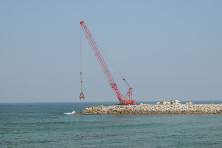 Crane on the wall - construction of a wall with a crane at the end to place stonesの写真素材