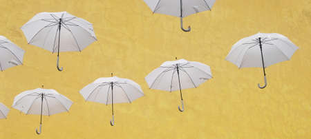 Floating white umbrellas with yellow texture backgroundの写真素材