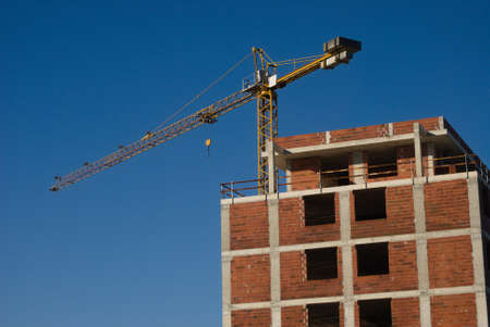 Building under construction with crane mounted - building, civil constructionの写真素材