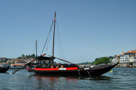 Rabelo boat with Distinguished name with Taylor's port wine barrels stopped at the pier of Vila Nova de Gaiaのeditorial素材