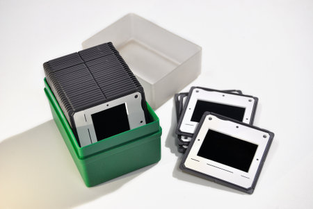 Box full of slides and some lying outside, white background, 35mm positive film