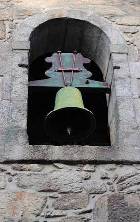 A bell set in an ancient stone structureの写真素材