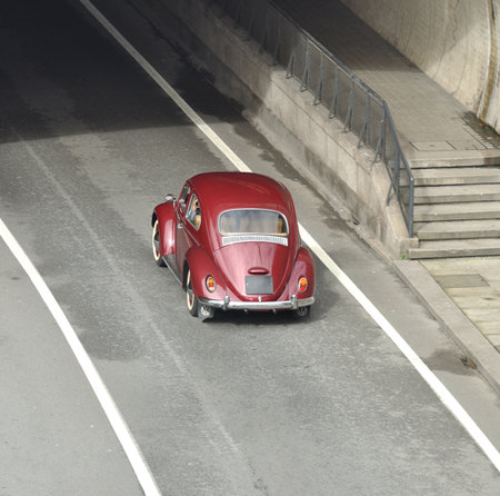 Old car driving on a road at the entrance to a tunnel, aerial viewのeditorial素材