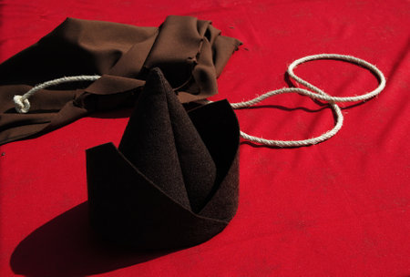 Friars' clothing accessories placed on top of a table with a red clothの写真素材