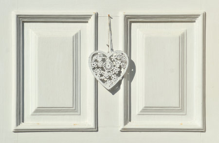 White wooden surface with two vertical rectangles and a white wooden heart hanging in the center,...