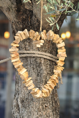 Heart made of wooden pads hanging from a tree, symbol of love and passionの写真素材