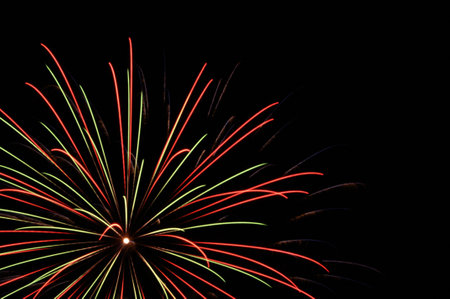 Small explosions of fireworks in the sky with yellow, red and green colorsの写真素材