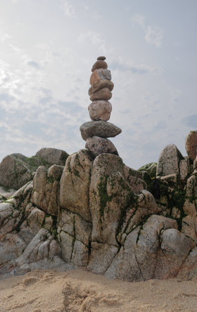 Zen therapy on a beach, stacking stones, well-being