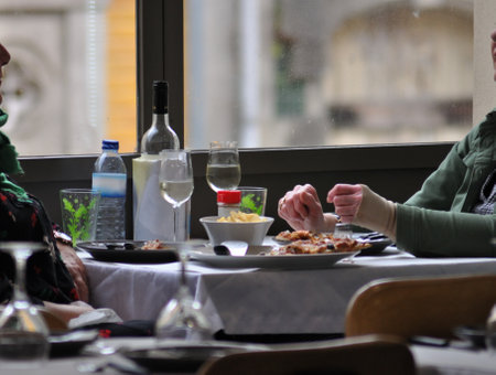 Restaurant in Porto, Portugal, with food on the table and a background window.の写真素材