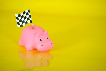 Piggy bank with checkered flag on a yellow backgroundの写真素材