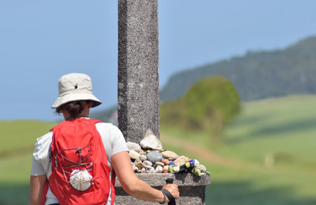 Hiker looking at the top of a stone pillar on a sunny dayの写真素材