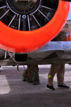 Aircraft maintenance worker repairing an airplane engine in the parking lot.の写真素材