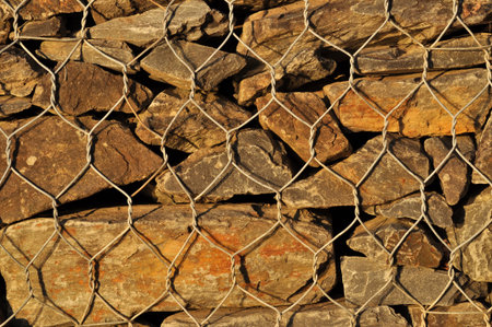 Close up of a stone wall with a wire mesh in the backgroundの写真素材