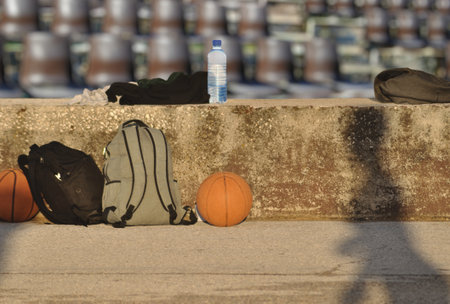 Basket of basketball and water bottle on the ground in the parkの写真素材