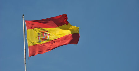 Spanish flag waving in the wind on blue sky background, Spain
