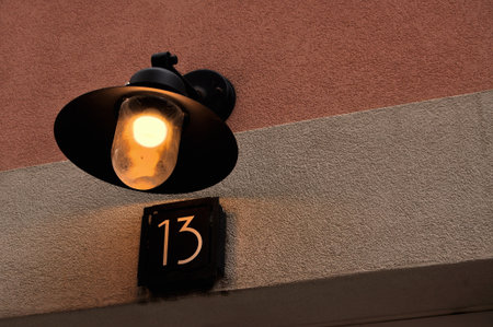 street lamp with number 13 on the wall of a building in the cityの写真素材