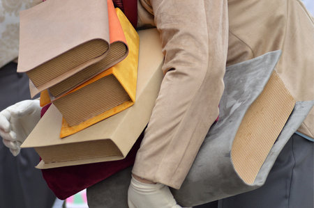 A close up shot of a pile of books in the hands of a personの写真素材