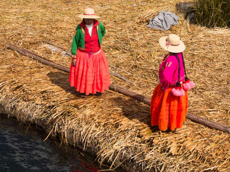 Women in colorful dresses on the pier in Reed Islands on Lake Titicaca in Peru.のeditorial素材