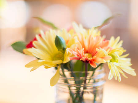 Mixed bouquet in jar on table with bokehの写真素材