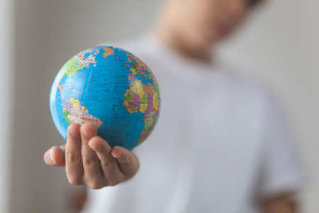 Boy holding toy globus in his hand. Day natural window lightの写真素材