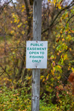 Easement sign to notify public fishing is allowed. Selective focus, background and foreground blur.の写真素材