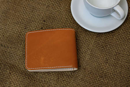 Men's brown leather wallet. With a touch of a netted background or texture.の写真素材