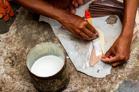 Magetan Leather Craft Workers. Portrait of a leather craftsman making sandals typical of Magetan, East Java - Indonesia.の写真素材
