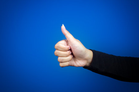 Thumbs up sign. Isolated on blue background