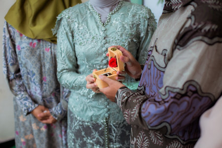 The bride and groom exchange rings at the wedding. A husband and wife put rings on each other's fingers. Holding a wedding ring. Precious metal jewelry for married couples.の写真素材