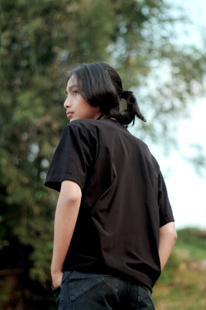 Clothing model. Young Asian man posing outdoors. Asian young man wearing black t-shirt. It was as if he was modeling a plain t-shirt.の写真素材