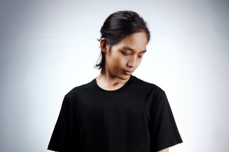 Asian men. Young Asian man close up shot isolated on white. Young Asian man wearing a plain black t-shirt isolated on a white background.の写真素材