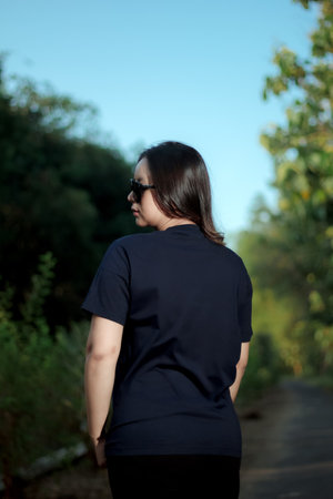 Clothing model. Young Asian woman with sunglasses posing outdoors. Asian woman wearing a plain Navy...