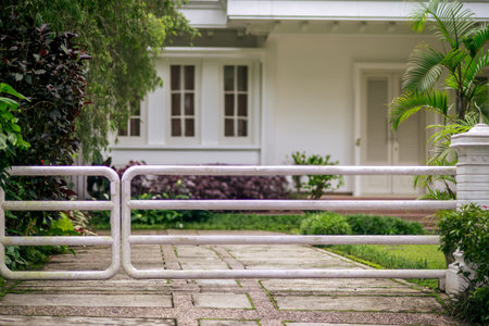 The white house fence is made of iron or trellis