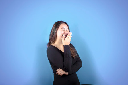 Portrait of a happy Asian woman smiling with her mouth covered