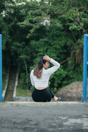 Young Asian woman wearing white casual clothes is posing outdoors showing her fashion and ootd. Stylish Asian woman with sunglasses outdoors.の写真素材