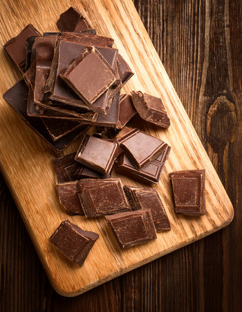 chocolate on a wooden cutting board, isolated against a wooden background