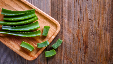 aloe vera on a wooden cutting board, isolated against a wooden backgroundの写真素材