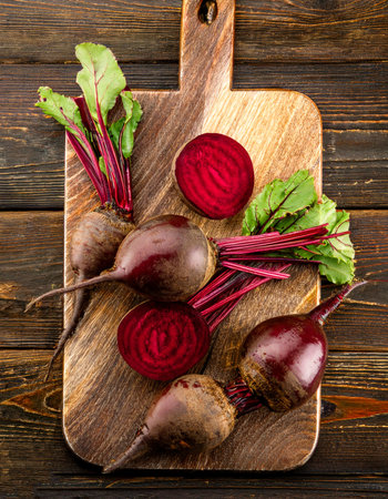 Red beetroot and beetroot cross sectoin on a wooden cutting board, isolated against a wooden...