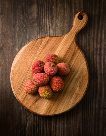 lychee on a wooden cutting board, isolated against a wooden backgroundの写真素材