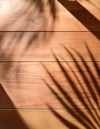 top view of soft brown table with high resolution texture and palm leaf shadows, summer table background with empty space for text or design, soft cozy sunny table backdrop, wooden texture seamlessの写真素材