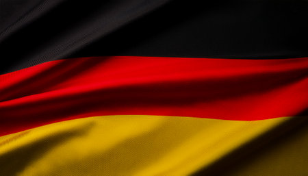 German flag waving in the wind. Close up of German banner blowing, soft and smooth silk. Cloth fabric texture ensign background. Use it for national day and country occasions conceptの写真素材