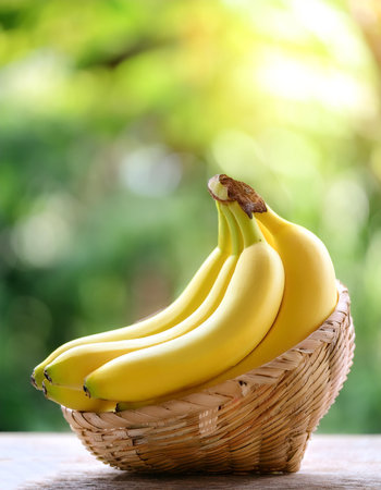 Banana in Bamboo basket with blur green bokeh backgroundの写真素材