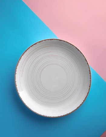 White ceramic round plate, isolated on a soft blue and Pink Pastelの写真素材