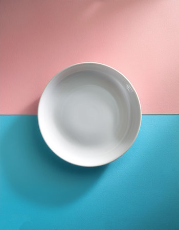 White ceramic round plate, isolated on a soft blue and Pink Pastelの写真素材