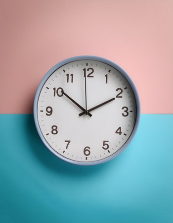 Minimalist style wall clock, showing time at 10:00, isolated on a soft blue and Pink Pastelの写真素材