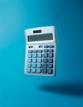 Calculator floating or flying isolated on light blue backgroundの写真素材