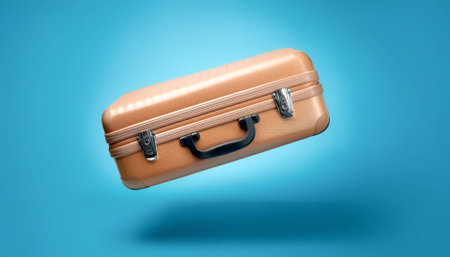 Classic suitcase floating or flying isolated on light blue backgroundの写真素材