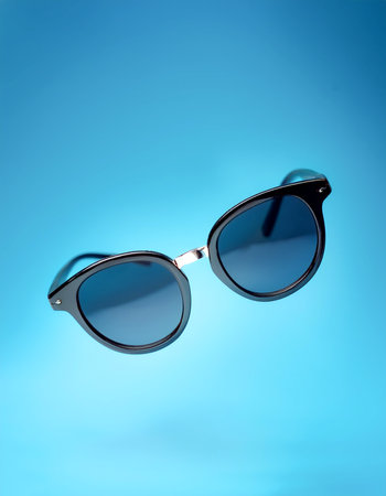 Sunglasses floating or flying isolated on light blue backgroundの写真素材